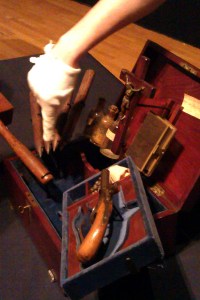 A museum employee points out interesting features of the Vampire Killing Kit